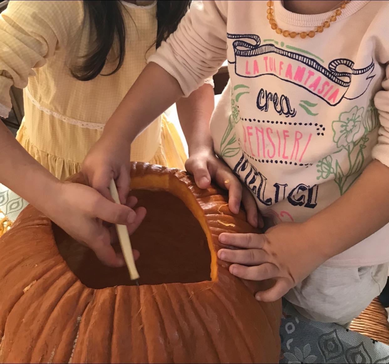 Due bambini intagliano una zucca di Halloween