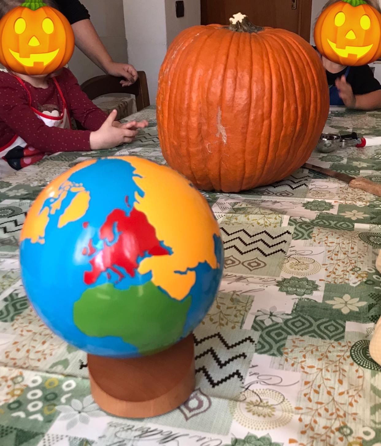 Una zucca di Halloween accanto ad un mappamondo